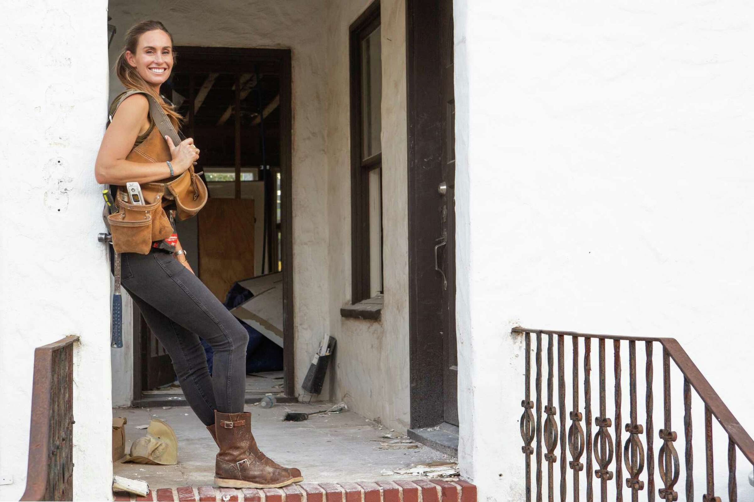 Kim Wolfe smiling in front of construction home